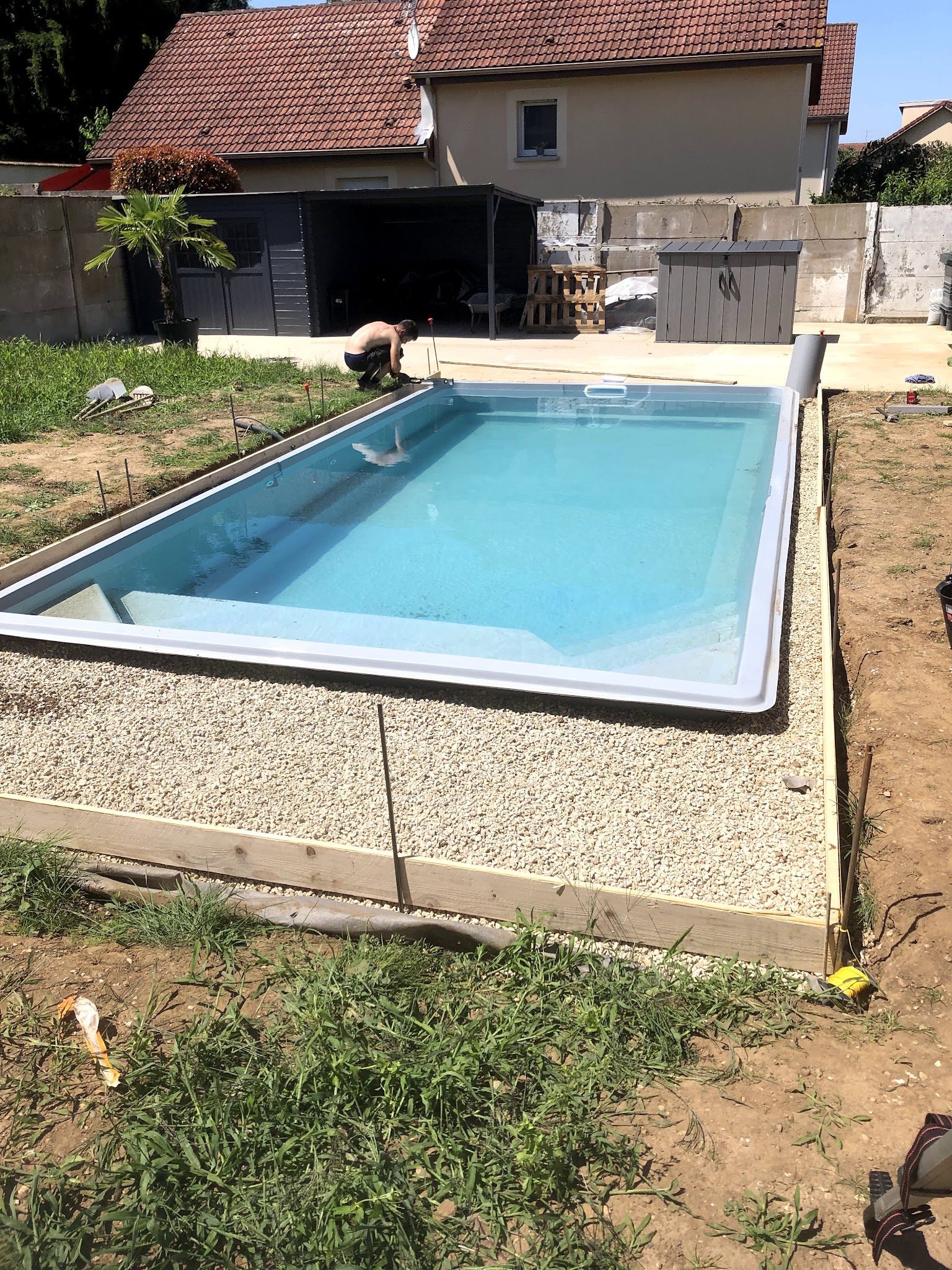 Terrassement et lit de gravier autour d'une piscine